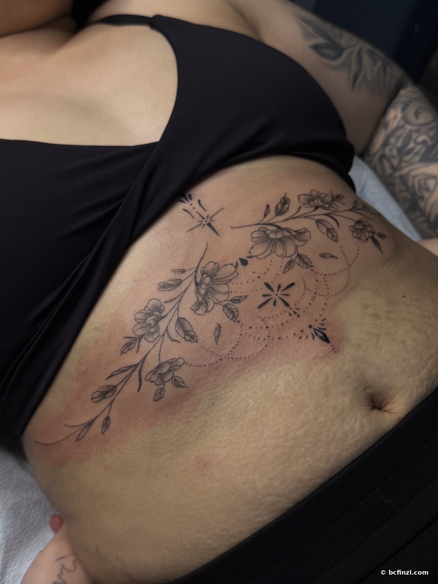 Floral vine — fine-line tattoo — on the hip — by Bianca Finzi, Austin TX